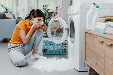 Woman,Checking,Her,Damaged,Washing,Machine,,The,Floor,Is,Flooded - Billy The Sunshine Plumber